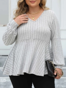 Detail of light grey V-neck peplum top showing ribbed knit texture and lantern sleeves