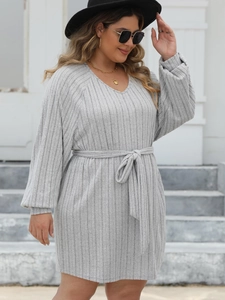 Detail of grey ribbed knit long sleeve dress with elegant waist tie and V-neckline