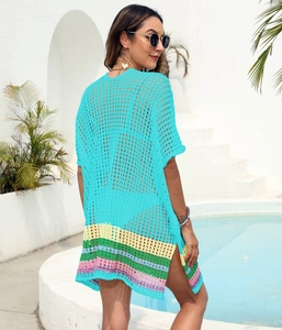 Detailed close-up of blue crochet beach cover-up with colorful striped hem and mesh knit