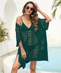 Close-up detail of dark green crochet knit texture on a bohemian beach cover-up dress