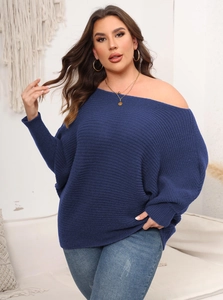 Detail of navy knit oversized sweater showing elegant off-shoulder neckline and ribbed cuffs