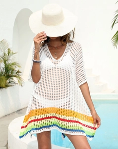 Detail of white crochet beach cover-up with vibrant colorful rainbow stripes on the hem
