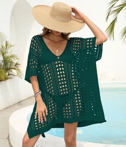 Detail of dark green crochet cover-up with deep V-neck and hollow knit texture