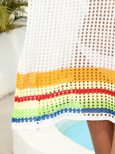 Close-up of white crochet beach dress with vibrant rainbow stripe knit details