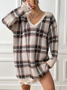 Detail of color-block plaid knit dress showing distressed hem and V-neck styling