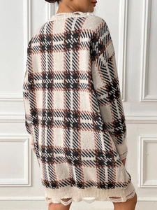 Detail shot of distressed hem and plaid pattern on a loose knit sweater dress