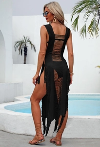 Detailed close-up of black crochet knit texture and long fringe on a beach cover-up