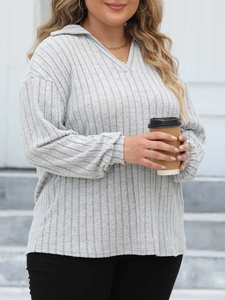 Close-up of women's light grey ribbed knit sweater with a polo collar and V-neckline