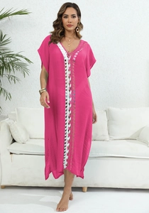 Detalle de vestido de playa fucsia de ganchillo con lazos tejidos blancos y calados