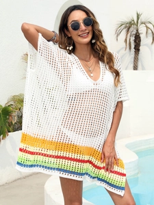 Detailed close-up of white crochet beach cover-up with rainbow stripes at the hem