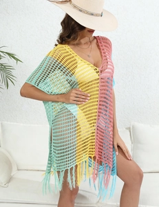 Detail of color-block crochet beach cover-up featuring hollow-out knit and long fringe hem