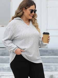 Close-up of light grey ribbed knit long sleeve polo shirt with V-neck and vertical stripes
