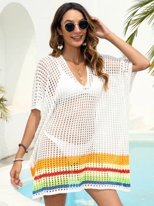 Detail of white crochet beach cover-up featuring deep V-neck and rainbow stripe hem