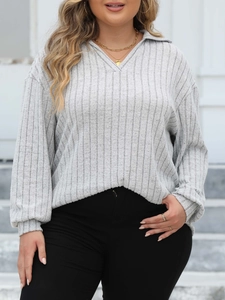 Close-up of grey ribbed knit texture and V-neck polo collar on women's long sleeve top