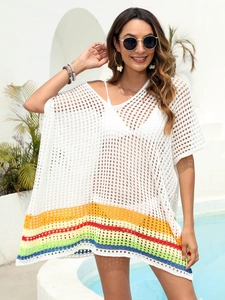 Detail of white crochet beach cover-up featuring rainbow striped hem and knit texture