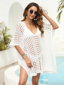 Detail of white crochet beach cover-up featuring intricate geometric hollow-out patterns