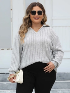 Detailed texture of grey long sleeve polo knit top with fine vertical ribbing design