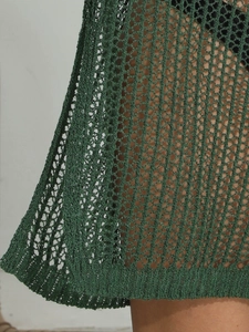 Close-up of deep green knit hollow-out texture and honeycomb mesh of the beach cover-up