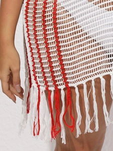 Close-up of red and white striped knit beach cover-up with detailed tassel hem