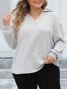 Detail of grey ribbed knit polo top featuring a V-neck collar and long cuffed sleeves