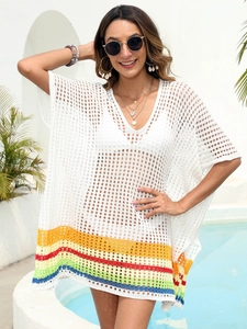 Detail of white crochet beach cover-up featuring rainbow stripes and loose hollow knit