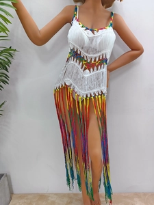 Détail de la maille arc-en-ciel crochetée main et des longues franges colorées sur robe de plage