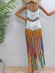 Détail d'une robe de plage bohème en crochet avec franges dégradées colorées et maille blanche