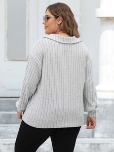 Detail of light grey polo collar knit top with vertical ribbed texture and long sleeves