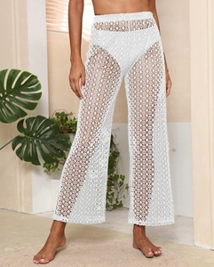 Détail du pantalon de plage en dentelle au crochet blanche à taille haute et motifs floraux