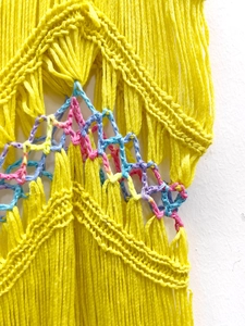 Détail du haut de plage tricoté à la main avec motifs géométriques colorés et franges