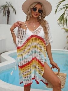 Détail de robe de plage au crochet bohème avec rayures colorées et pompons latéraux