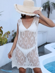 Detail of white knit beach cover-up featuring geometric hollow patterns and deep V-neck