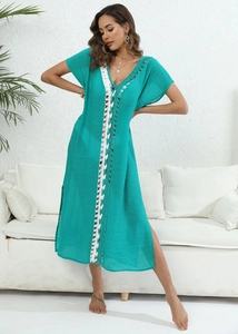 Detailed view of deep V-neck turquoise beach dress with white crochet stitching