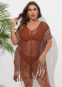 Detail of V-neck crochet beach cover-up featuring white stripes and long fringe tassels