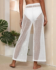 Détail de dentelle blanche crochetée sur le pantalon de plage évasé à taille haute