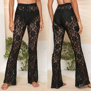 Detailed view of floral lace texture and flared hem on high waist black trousers