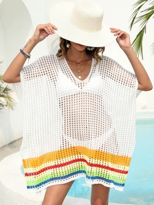 Detail of white crochet beach cover-up with rainbow stripe hem and deep V-neckline