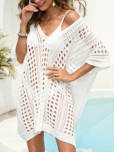 Detail of white crochet beach cover-up with geometric hollow pattern and V-neckline