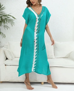Close-up of turquoise beach cover-up featuring intricate white crochet lace details and slits