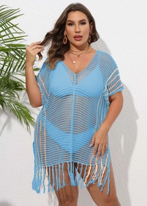 Detail of blue crochet beach cover-up featuring open knit texture and long fringe tassels