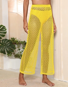 Détail du pantalon large en dentelle au crochet jaune vif avec motif floral ajouré