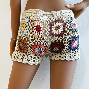 Detailed view of colorful crochet floral patterns on handmade bohemian beach shorts