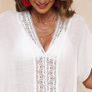 Detailed close-up of intricate white lace crochet on a V-neck bohemian beach cover-up dress