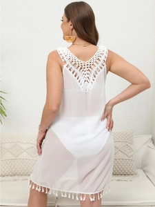 Detail of white crochet V-neck back design with fringe on bohemian beach cover-up