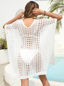 Macro detail of white crochet bikini cover-up featuring deep V-back and hollow knit patterns