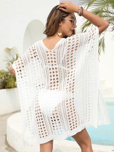Detail of white crochet beach cover-up featuring openwork patterns and V-shaped back