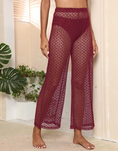 Détail de la texture crochetée en dentelle bordeaux sur le pantalon large de plage