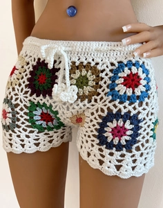 Detail of crochet beach shorts with colorful sunflower patterns and waist drawstring