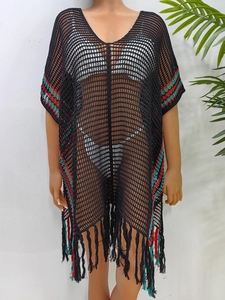 Détail de la robe de plage en crochet noir avec rayures colorées et bordures à franges