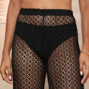 Détail du pantalon en dentelle noire au crochet à taille haute avec motifs géométriques